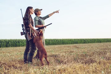 Rolgordijnen Women hunters with hunting dog  © zorandim75
