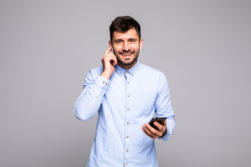 Young handsome man talk vie air beans on the phone isolated on gray background