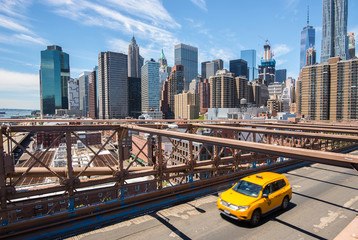 New York Manhattan skyline from the Brooklyn Bridge with yellow taxi