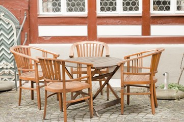 A wooden table with four chairs in front of an half-timbered house (Bacharach, Germany, Europe)