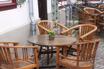 A wooden table with four chairs and a little plant with yellow flowers (Bacharach, Germany, Europe)