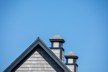 Fototapeta na wymiar Blue and grey rooftop with two chimneys