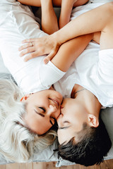 young lovely couple lying in a bed, happy smile