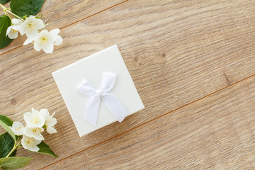 Gift box with flowers on the wooden background.
