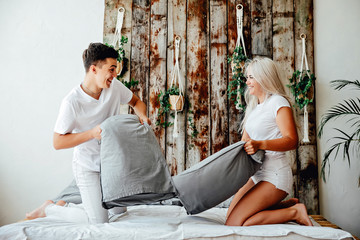 Happy young couple is having fun in bed.