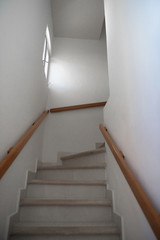 White stairs leading to the next floor. Wooden handrails.