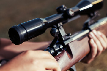 Woman hunter loading bullet to carbine