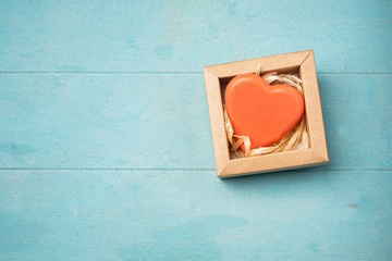 Soap in the form of a heart in a gift box on a blue background, top view, copy space. Natural handmade soap.