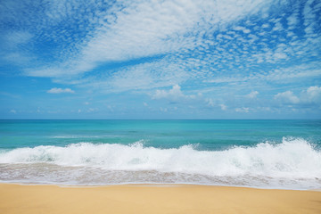 Soft wave of blue ocean on sandy beach in summer season. Background with blue sky.