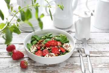 Salad with strawberries, ricotta cheese and green lettuce with walnuts and balsamic dressing