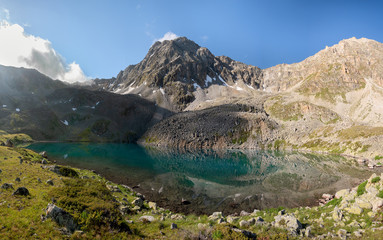 Naklejka na ściany i meble Alpine lake with clear water near the mountain Dzhalkaush, Teberda, Karachay-Cherkess Republic, Russia