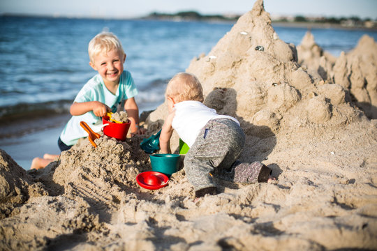 Geschwister bauen eine Sandburg