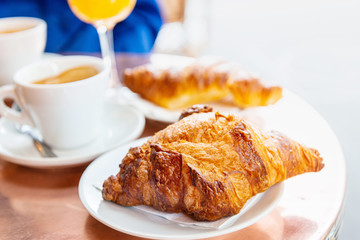 Breakfast with coffee and croissants on table