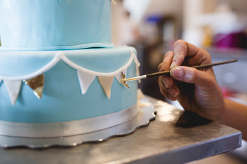 A woman decorates and makes cakes in a pastry shop