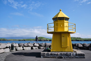 Fototapeta na wymiar Yellow Lighthouse and fisherman