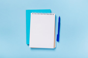 school notebook on a blue background, spiral notepad on a table