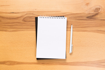 school notepad and pen on the wooden desk. spiral notepad on a tableschool notepad and pen on the wooden desk. spiral notepad on a table