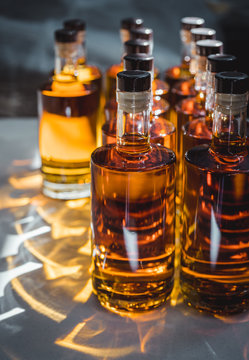 Small liquor production based on maple syrup. Multitude of pure alcohol bottles not labeled. Bottles placed in a row.