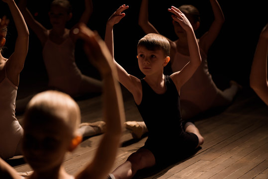 Children doing splits while warming up on the stage