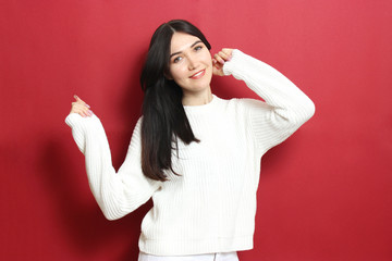 Beautiful girl in a warm cozy sweater on a colored background.