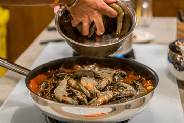 Delicious Tiger Prawns or Shrimps in tomato sauce and herbs on a pan. Italian cuisine.