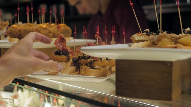 Showcase window display assortiment with tapas &ndash; traditional Spanish sandwiches in a cafe in Barcelona, Spain close up macro