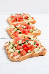 Italian bruschettas with sliced tomato cucumbeand vegetables. Vegetarian bread toast with fresh cucumber and tomato.
