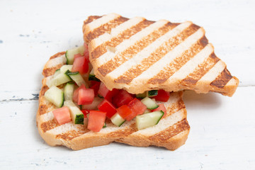 Italian bruschettas with sliced tomato cucumbeand vegetables. Vegetarian bread toast with fresh cucumber and tomato.