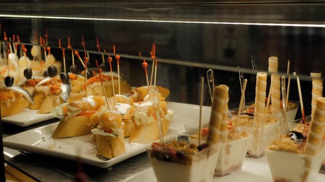 Showcase window display assortiment with tapas &ndash; traditional Spanish sandwiches in a cafe in Barcelona, Spain close up macro