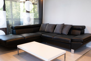 Modern interior of living room with comfortable black leather sofa
