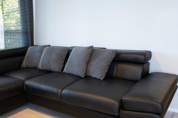 Modern interior of living room with comfortable black leather sofa