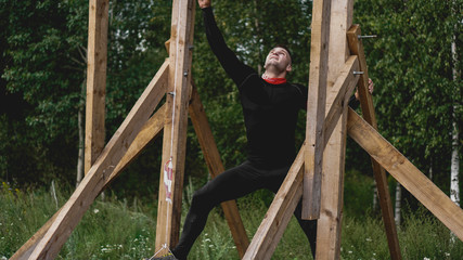 Man passing through hurdles during obstacle course in boot or sport competition