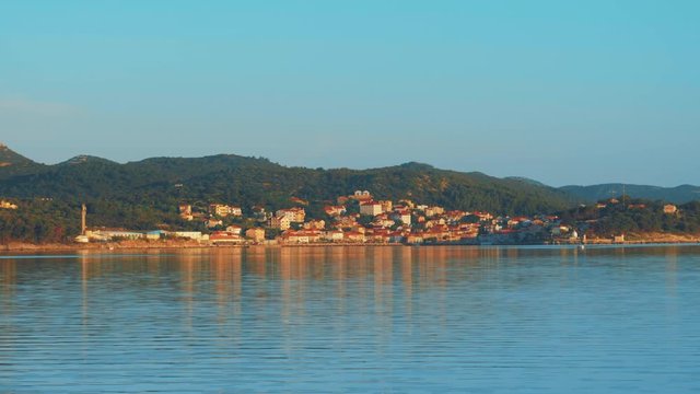 Beautiful shoot from the sea of a small town on Dugi otok, Croatia on the sunset at summertime. Beautiful orange colors.