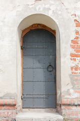 Fototapeta na wymiar The entrance to the old stone building, metal door