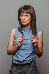 Portrait of beautiful model woman with long hair and makeup on gray background ..