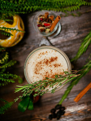 Brown cocktail in a glass goblet on a long leg. In the tropical garden. On a flat stone.