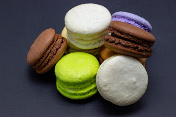 Colorful macaroons or macaroni cake on a dark background. A french sweet delicacy