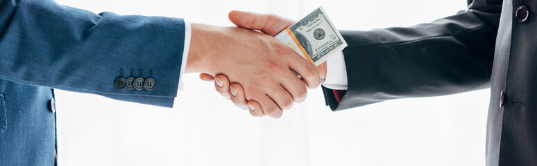 cropped view of man taking envelope with cash near business partner holding clipboard and contract
