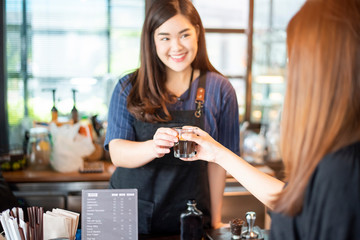 Close up of female hand is taking hot coffee from Barista