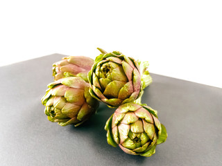 Fototapeta premium Artichokes isolated on grey and white background. Fresh organic artichoke flowers with front view