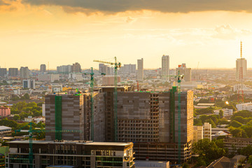 Construction site, Construction crane and modern city at sunset.