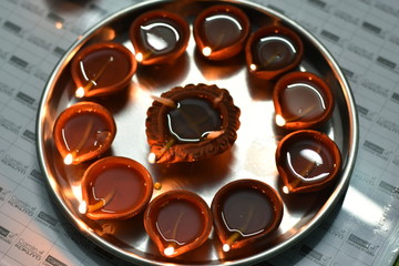 beautiful terracotta lamps in a plate on a white board