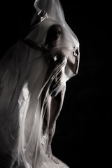 Slim girl dressed only in underwear emotionally posing, wrapped in fluttering in the wind and...