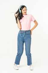 Happy asian teen passenger listening to the music with headphones while holding  mobile phone.businesswoman listening to music with headphones while dancing isolated over white background