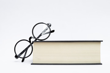 Design reading glasses on thick book isolate on white background, education concept