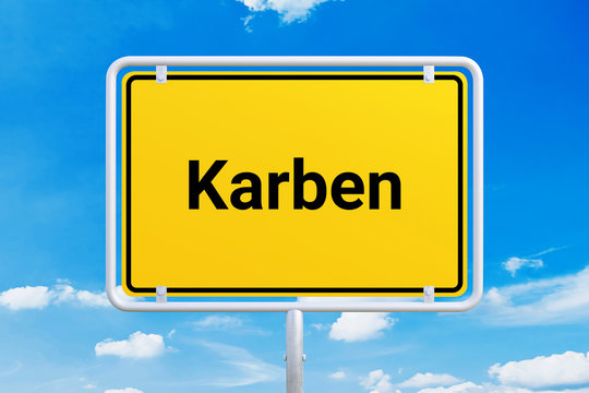 Stadt Karben. Gelbes Schild, Ortsschild, Ortseingangsschild. Himmel mit Wolken.