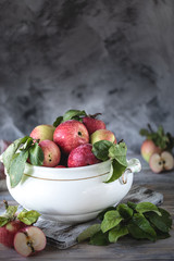 Red and green apples in a white ceramic bowl