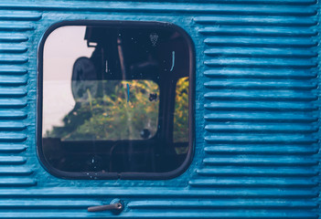Glass window of old vintage train with blue container abstract travel background