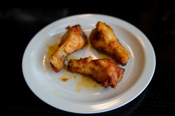 Fried chicken legs with a crust in a plate on a black table
