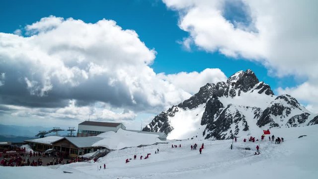 Tourism play air board on snow at Shanzidou highest peak of Jade Dragon Snow mountain or Yulong Xueshan Mountains in Yulong Naxi Autonomous County, Lijiang, Yunnan, China (4K timelapse)